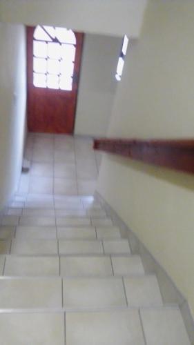 an empty room with a door and a tile floor at Emampingeni lodge in Bizana