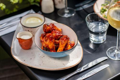 a plate of chicken wings on a table with a glass of wine at Kildare House Hotel in Kildare