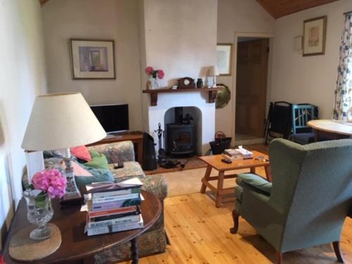 a living room with a couch and a table with books at Cottage by the Sea, West Cork, Ireland in Kilbrittain