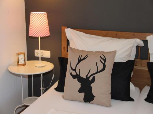Una cama con una almohada con una silueta de ciervo. en Casa Claudia - die schöne 4-Sterne-Fewo - im Sommer Bergbahntickets inclusive, en Oberstdorf