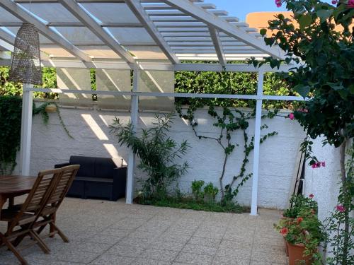 a patio with a pergola and a table and chairs at Mansarda sul Mare in Torre Lapillo