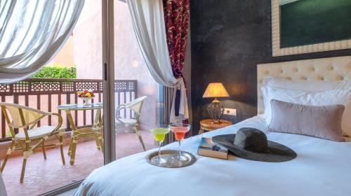 a bedroom with a bed with a hat and drinks on it at dar al walidine in Marrakesh
