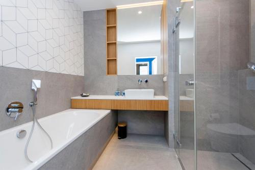 ein Bad mit einer Badewanne, einem Waschbecken und einer Dusche in der Unterkunft Apartament Rodzinny Portova in Gdynia