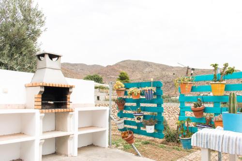 a garden with blue and white walls and potted plants at VILLA AURORA NÍJAR Parque Natural Cabo Gata in Níjar