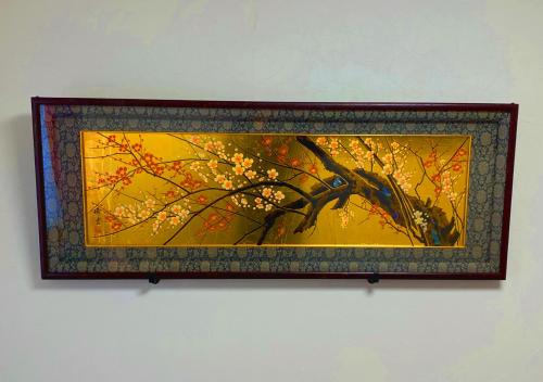 a painting of a tree with flowers on a wall at Maguro House in Osaka