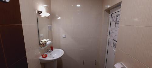 a white bathroom with a sink and a shower at MARIANA - guest rooms in Gotse Delchev