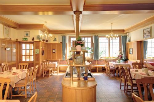 - un restaurant avec des tables et des chaises dans une salle dans l'établissement TIPTOP Hotel Garni Pfauen, à Endingen am Kaiserstuhl