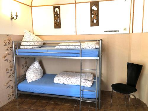 ein Etagenbett mit Kissen und einem Stuhl in einem Zimmer in der Unterkunft Apartment in Alf in Alf