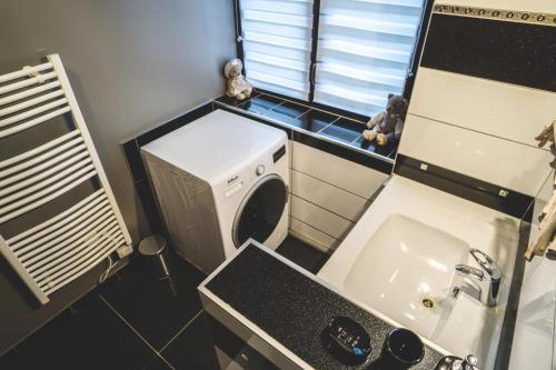 een kleine keuken met een wasmachine en een wastafel bij Superbe appartement 2 a 6 pers. hyper cocooning in Gérardmer