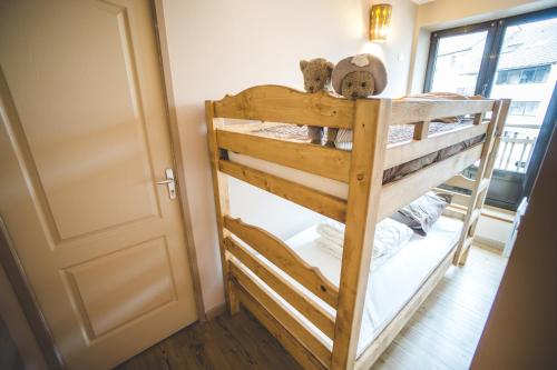 een houten stapelbed in een kamer met een deur bij Superbe appartement 2 a 6 pers. hyper cocooning in Gérardmer