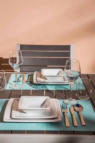 a table with plates and wine glasses on it at Apartment Lilly, apartment with communal pool, 10 meters from sea in Sami