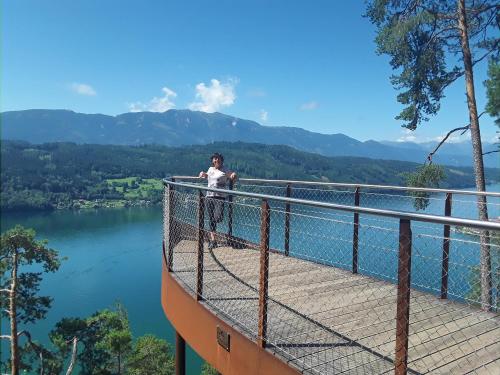 a person standing on a viewing platform overlooking a lake at Haus Harmonie in Millstatt