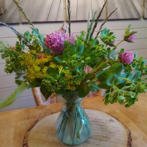 a blue vase filled with flowers on a table at Chalet La Bachole in Charancieu