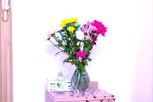 a vase filled with flowers sitting on a table at Allen Luxury Apartment in Coventry