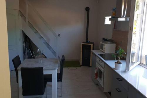 a small kitchen with a table and a microwave at Joli Studio confort indépendant coeur de Sologne in Lamotte-Beuvron