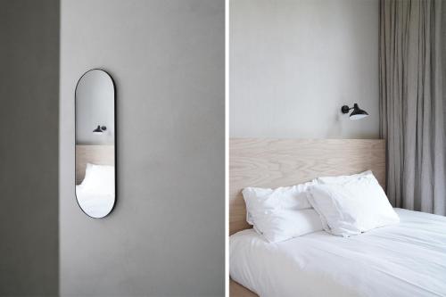 a bedroom with a mirror on the wall next to a bed at Hotel âme in Rotterdam