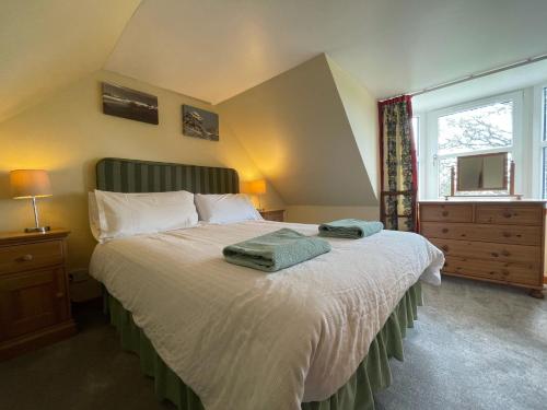 a bedroom with a bed with two towels on it at West Gorton in Grantown on Spey