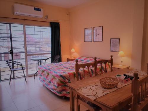 a bedroom with a bed and a table and a balcony at B3 Apartments in Formosa