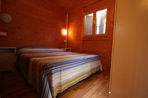 una piccola camera con letto e finestra di CAMPING CALATELLA parco di vacanza a Marina di Massa