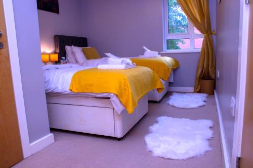 two beds in a bedroom with rugs in the floor at Allen Luxury Apartment in Coventry