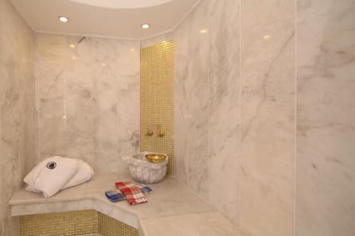 a bathroom with a shower with a towel and a sink at Cella Hotel & SPA Ephesus in Selcuk