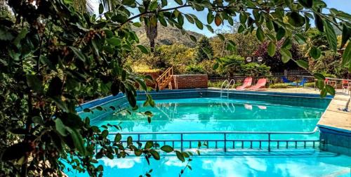 a swimming pool with blue water in a yard at Hosteria Pastoral & Spa in La Cumbre