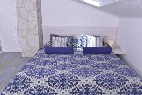 a bedroom with a blue and white bed with pillows at Cella Hotel & SPA Ephesus in Selcuk
