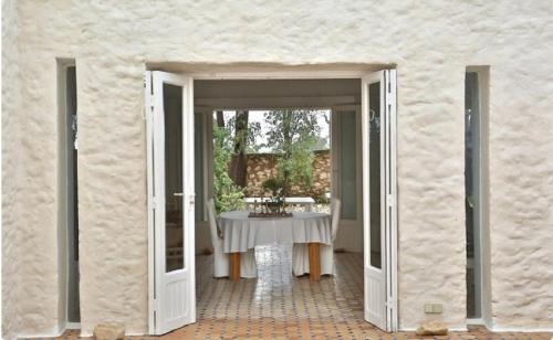 an open door to a patio with a table outside at Unique Architect's House in Essaouira