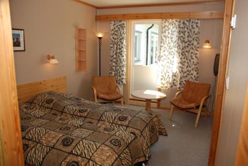 um quarto com uma cama, uma mesa e cadeiras em Ljosland Fjellstove em Ljosland
