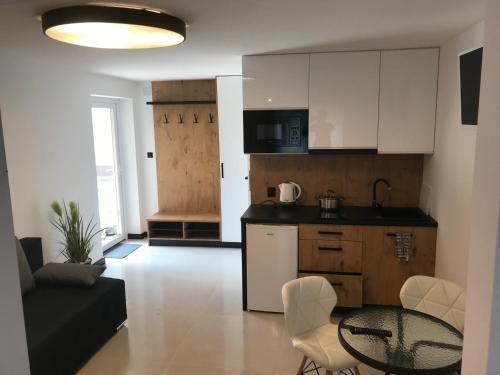 cocina y sala de estar con mesa y sillas. en Apartamenty Chata u Rybaka, en Jantar