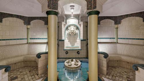 ein Zimmer mit einem Brunnen in einem Gebäude mit Säulen in der Unterkunft Hotel Almesberger in Aigen im Mühlkreis