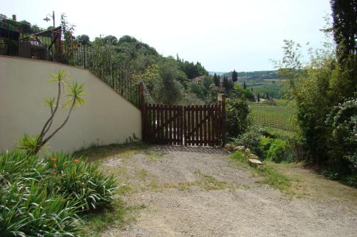 a wooden gate in a yard with a vineyard at Casa Natura in San Gimignano
