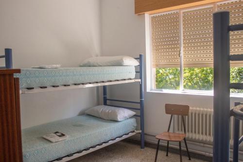 two bunk beds in a room with a window at Albergue Santa Olaia in Silleda