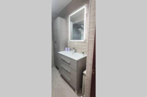 uma casa de banho com um lavatório e um espelho em Estrenar! Con PINBALL + 8 min ayto + 2 habs 1.50 em Oviedo