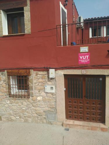 a building with a door and a sign on it at El Canchal de Eladia in Valdeverdeja