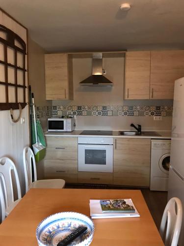 a kitchen with a wooden table and a kitchen with a sink at El Canchal de Eladia in Valdeverdeja