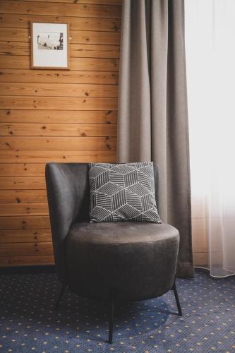 a chair with a pillow sitting in a room at Hotel Sonnenhalde, Arosa in Arosa