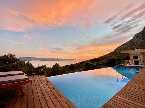a swimming pool with a sunset in the background at Villa FORTE-Exclusive location with fantastic seaview & infinity pool - up to 8 Pax in Mimice