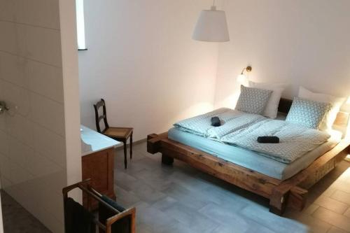a bedroom with a wooden bed and a chair at Villa Hinterland in Biedenkopf
