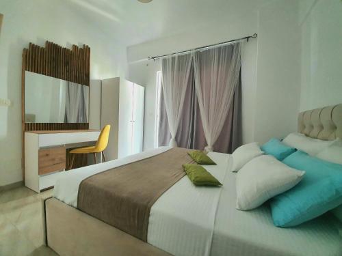 a bedroom with a large bed and a desk at Alba Apartments in Sarandë