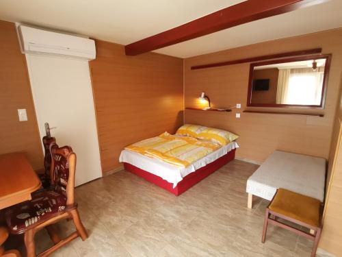 a bedroom with a bed and a table and a chair at Mini Villa in Hajdúszoboszló