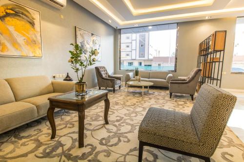a living room with a couch and chairs and a table at Golden Garden Serviced Apartments -King Faisal Dt in Riyadh