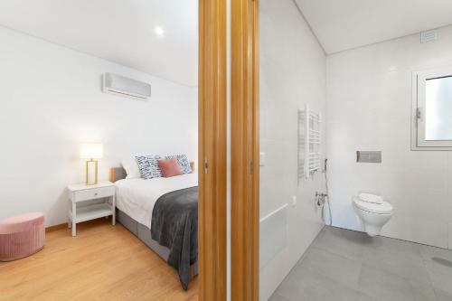 a bedroom with a bed and a bathroom with a toilet at Varandas do Sítio - By SCH in Nazaré