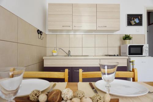 a kitchen with a table with two plates and glasses at Apartment Jelena in Fažana