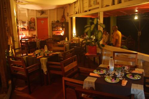 a restaurant with tables and chairs in a room at Idylle Beach in Sainte Marie