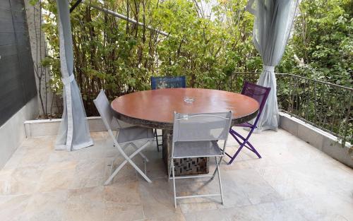 une table et des chaises en bois sur un balcon dans l'établissement entre mer et montagne, à Peyroules