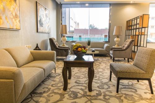 a lobby with a couch and chairs and a table at Golden Garden Hotel Suites in Riyadh
