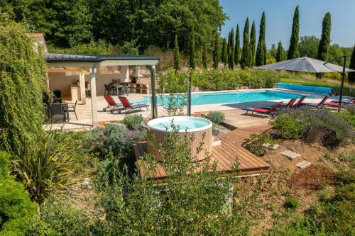a pool in a garden with chairs and a house at Les Cazettes in Damiatte