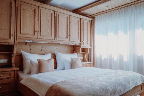 a bedroom with a large bed and a window at Das Verwall - finest serviced apartments in Lech am Arlberg