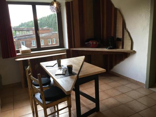 une table et des chaises dans une cuisine avec une fenêtre dans l'établissement Bois & Repos, à Malmedy